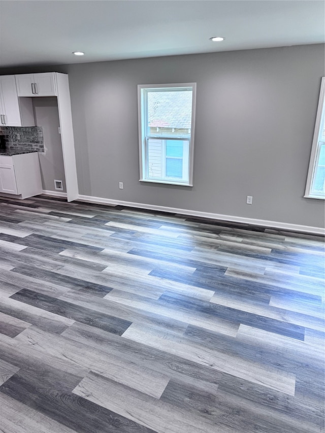 unfurnished living room with hardwood / wood-style floors and a healthy amount of sunlight