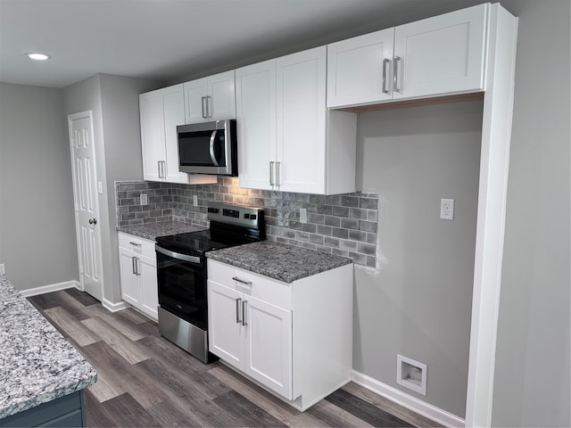 kitchen with hardwood / wood-style floors, white cabinetry, tasteful backsplash, stainless steel appliances, and light stone counters