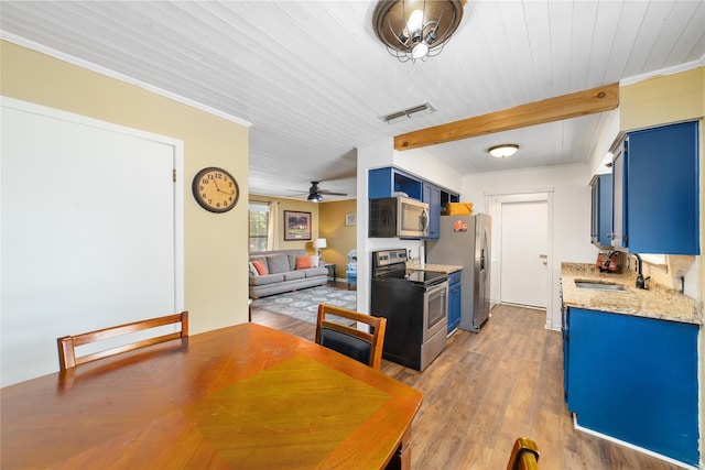 kitchen with dark wood-type flooring, sink, blue cabinetry, appliances with stainless steel finishes, and light stone counters