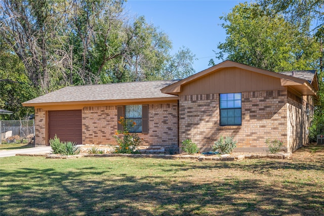 ranch-style house featuring a front yard and a garage