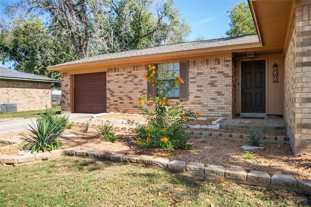 single story home with a garage and central AC unit