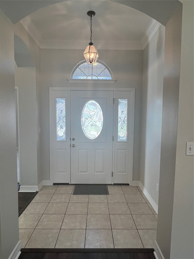 foyer entrance featuring crown molding and light tile patterned floors