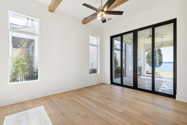 empty room with french doors, light hardwood / wood-style flooring, and a wealth of natural light