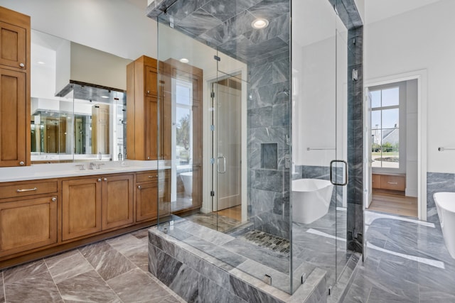 bathroom featuring vanity, independent shower and bath, and tile walls