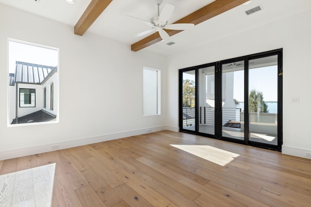 empty room with beam ceiling, ceiling fan, and light hardwood / wood-style flooring