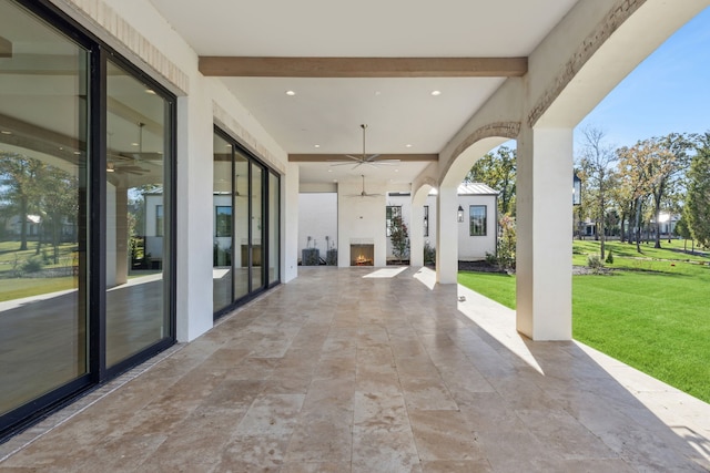 view of patio with ceiling fan and an outdoor fireplace