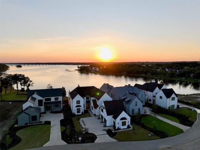 aerial view at dusk featuring a water view