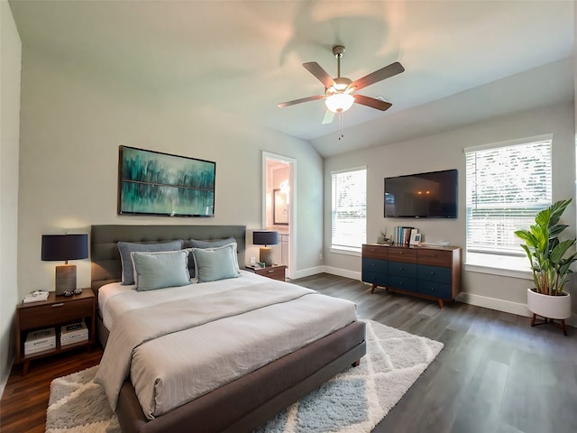 empty room with vaulted ceiling, ceiling fan, plenty of natural light, and dark hardwood / wood-style flooring