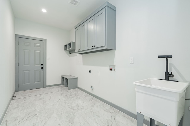 clothes washing area with hookup for a washing machine, cabinets, and hookup for an electric dryer