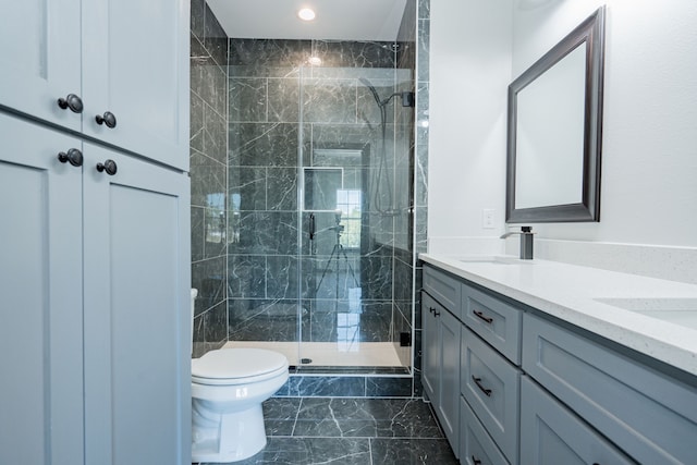 full bathroom with a shower stall, a sink, marble finish floor, double vanity, and toilet