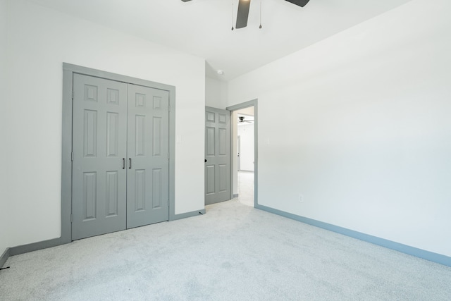 unfurnished bedroom featuring a closet, light colored carpet, and ceiling fan