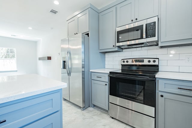 kitchen with stainless steel appliances, visible vents, decorative backsplash, gray cabinetry, and marble finish floor