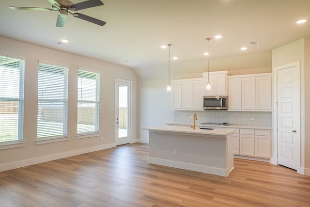 kitchen with light hardwood / wood-style floors, plenty of natural light, and white cabinetry