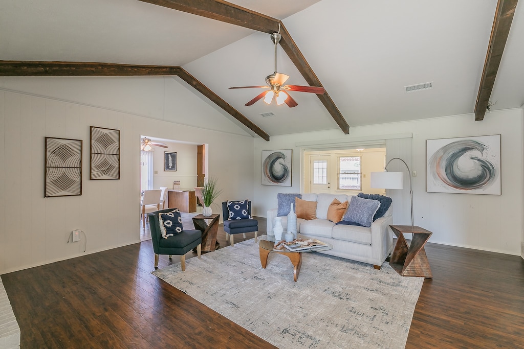 living room with dark hardwood / wood-style flooring, ceiling fan, and lofted ceiling with beams