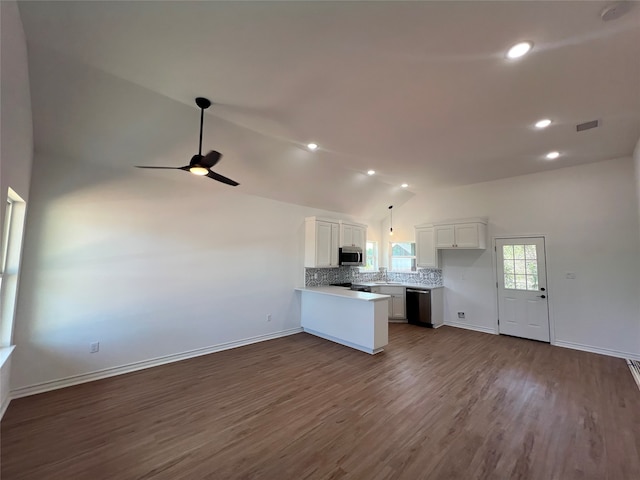 kitchen with decorative light fixtures, vaulted ceiling, stainless steel appliances, backsplash, and white cabinetry