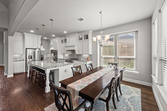 dining space with sink, a notable chandelier, and dark hardwood / wood-style flooring