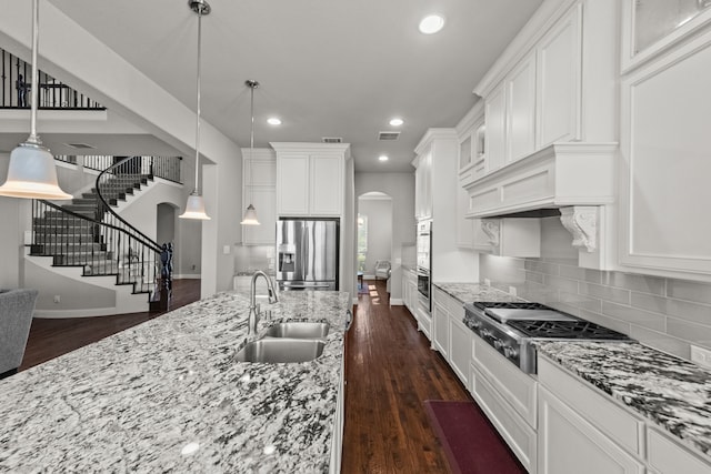 kitchen featuring sink, dark hardwood / wood-style flooring, backsplash, and appliances with stainless steel finishes