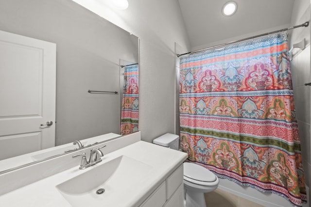 bathroom featuring vaulted ceiling, toilet, and vanity