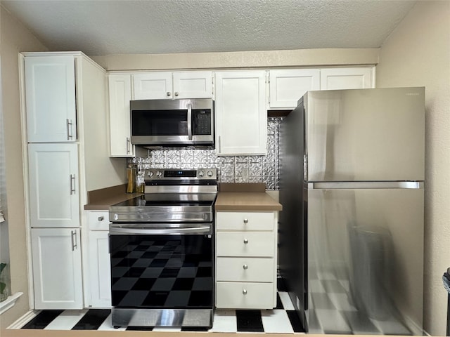 kitchen with white cabinetry, appliances with stainless steel finishes, decorative backsplash, and a textured ceiling