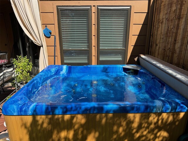 rear view of house featuring a yard, a hot tub, and a deck