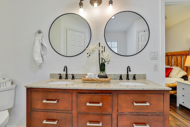 bathroom with dual vanity, hardwood / wood-style floors, and toilet