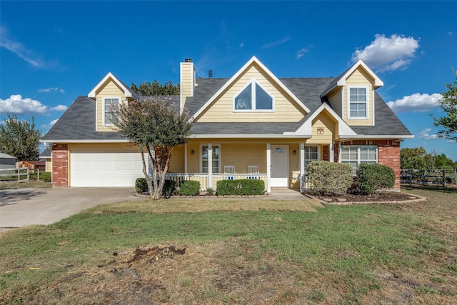 new england style home with a garage, covered porch, and a front yard