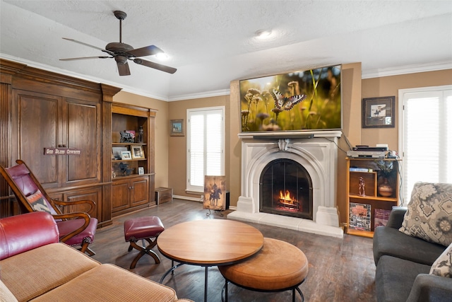 living room with a textured ceiling, ceiling fan, hardwood / wood-style floors, and crown molding