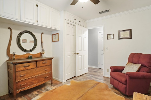 sitting room with light hardwood / wood-style floors, crown molding, and ceiling fan