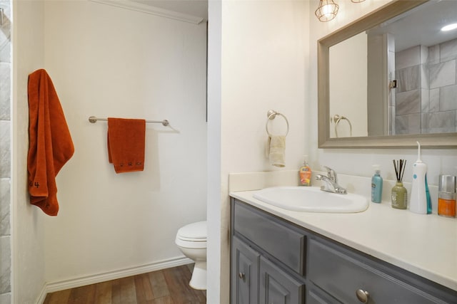 bathroom with hardwood / wood-style floors, toilet, ornamental molding, and vanity