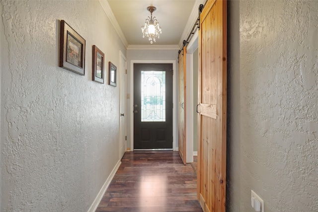 doorway with dark hardwood / wood-style flooring, an inviting chandelier, a barn door, and ornamental molding