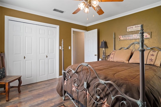 bedroom featuring ceiling fan, dark hardwood / wood-style floors, ornamental molding, and a closet