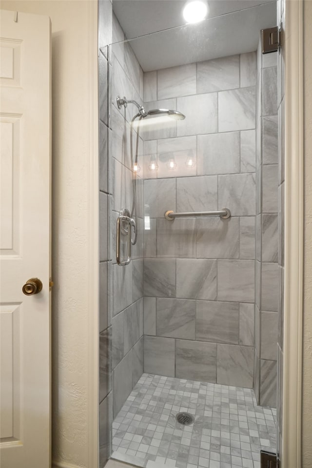 bathroom with a shower with door