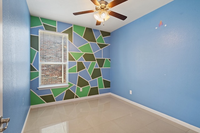 tiled spare room with ceiling fan