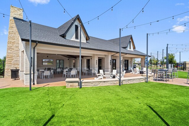 rear view of house with a patio and a lawn