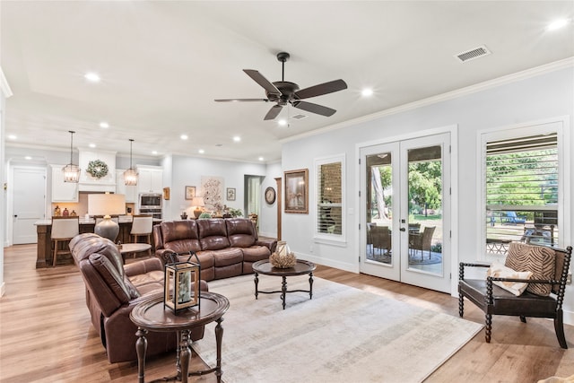 living room featuring ceiling fan, french doors, light hardwood / wood-style flooring, and ornamental molding