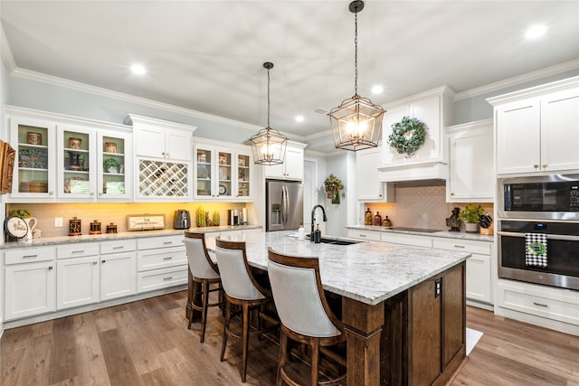 kitchen with sink, light wood-type flooring, decorative backsplash, stainless steel appliances, and white cabinets