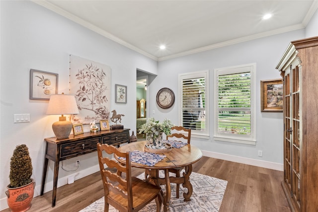 dining area with ornamental molding and hardwood / wood-style flooring