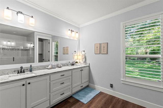 bathroom with a wealth of natural light, crown molding, dual vanity, and wood-type flooring