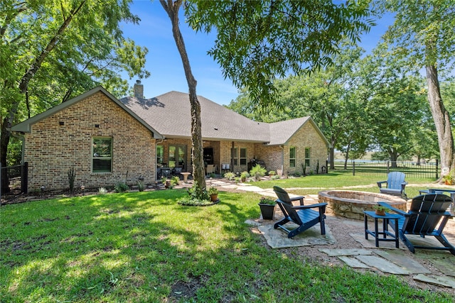 back of house with a patio, a fire pit, and a lawn