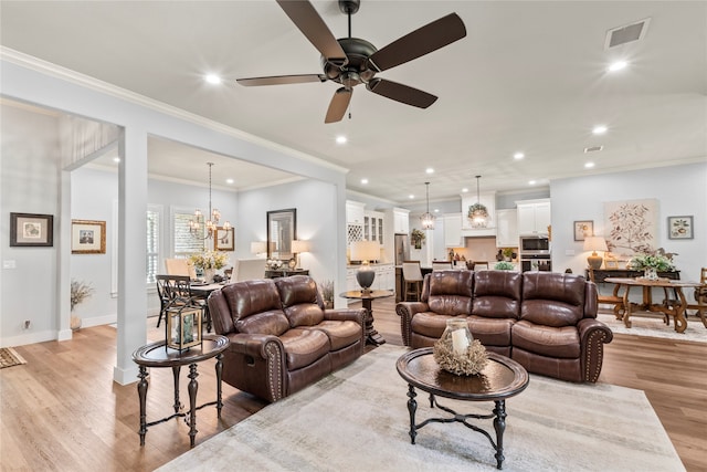 living room with crown molding, light hardwood / wood-style flooring, and ceiling fan with notable chandelier