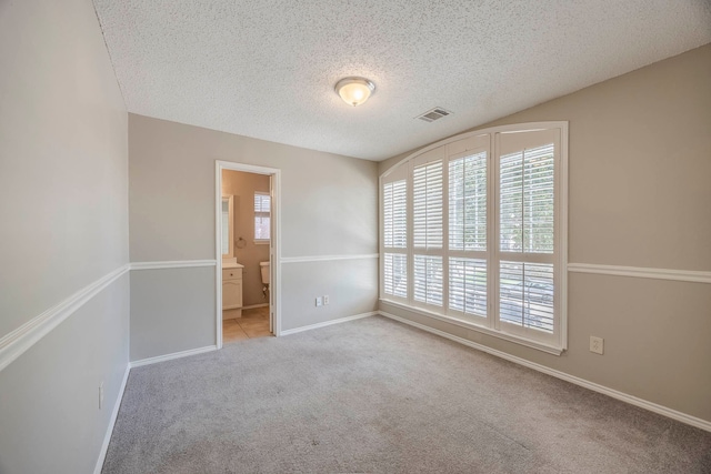 carpeted spare room featuring a textured ceiling