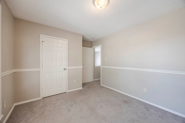 unfurnished bedroom with a textured ceiling, light carpet, and a closet