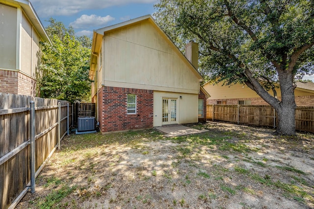 rear view of house with french doors and central AC unit