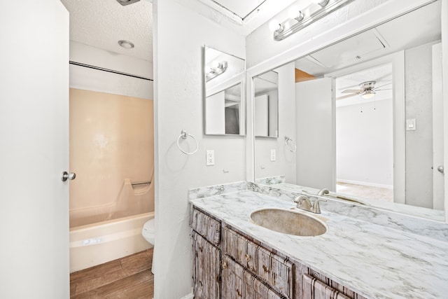 full bathroom featuring ceiling fan, tub / shower combination, toilet, and vanity