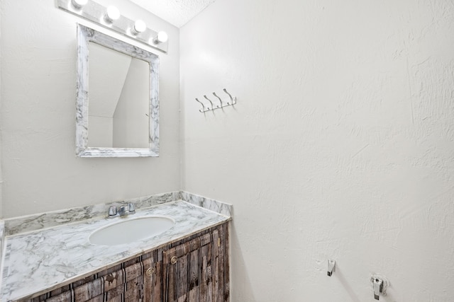 bathroom featuring a textured ceiling and vanity