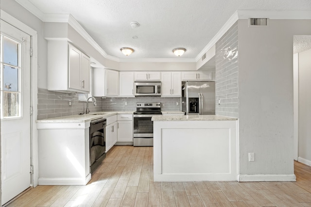 kitchen with white cabinetry, sink, stainless steel appliances, and tasteful backsplash