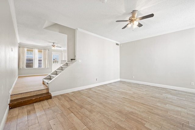 spare room with ceiling fan, light wood-type flooring, a textured ceiling, and crown molding