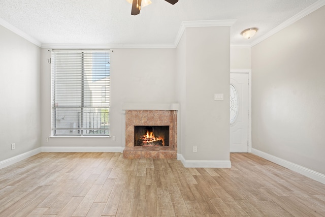 unfurnished living room featuring ceiling fan, ornamental molding, and light wood-type flooring