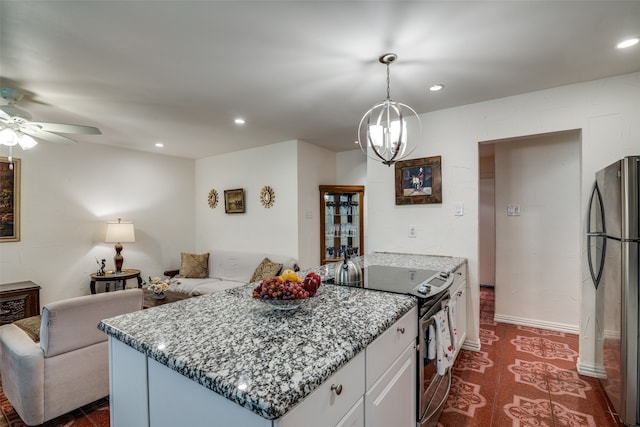 kitchen with electric stove, ceiling fan with notable chandelier, dark carpet, decorative light fixtures, and stainless steel fridge