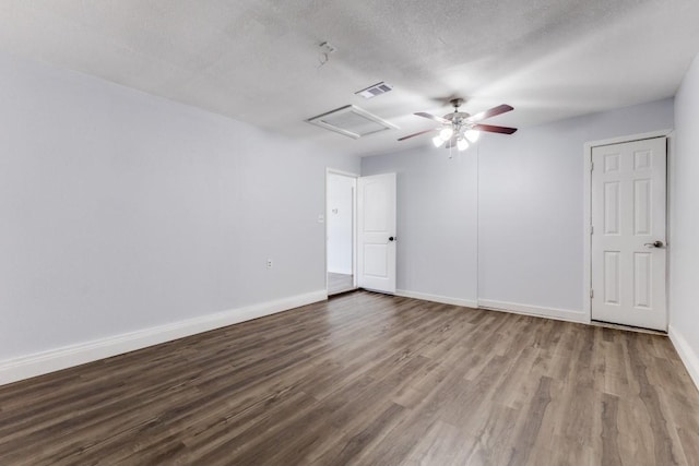 empty room with wood-type flooring and a textured ceiling